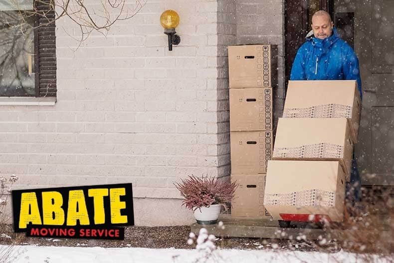 movers loading truck snowy driveway.1